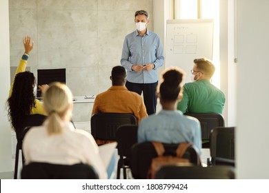 Male Professor Wearing Protective Face Mask While Holding A Lecture To A Group Of University Students. 