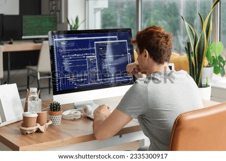 Male programmer working with computer at table in office