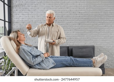 Male psychologist with pocket watch hypnotizing woman in office - Powered by Shutterstock