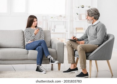 Male Psychologist Working With Young Girl In Office