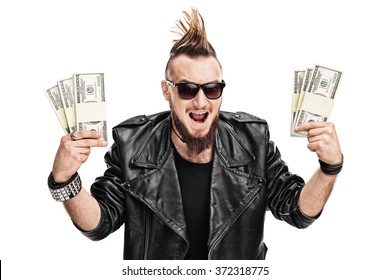 Male Punk Rocker Holding A Few Stacks Of Money And Looking At The Camera Isolated On White Background