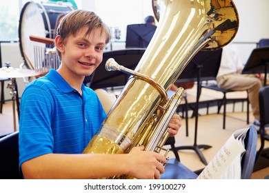 Male Pupil Playing Tuba In High School Orchestra