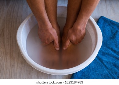 Male Put Hands And Feet In Bath With Hot Water And Baking Soda At Home. Homemade Bath Soak For Dry Feet Skin