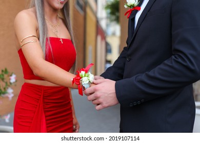 A Male Putting A Corsage On His Partner For Their Year 12 Formal- Prom As A Sign Of Love. 