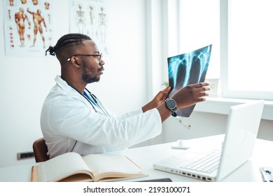 Male radiologist analyzing chest X-ray of an patient at medical clinic during coronavirus epidemic. Doctor with radiological chest x-ray film for medical diagnosis on patient's health on asthma - Powered by Shutterstock
