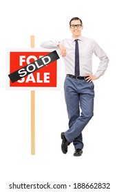 Male Real Estate Agent Leaning On A Sold Sign Isolated On White Background