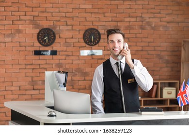 Male Receptionist Talking On Phone In Hotel