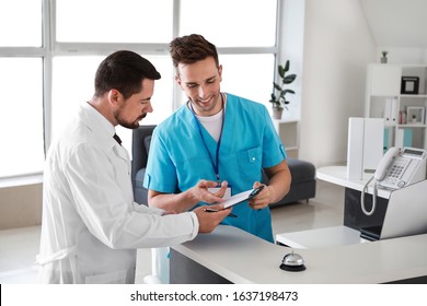 Male Receptionist Working With Doctor In Clinic