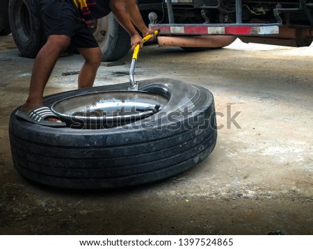 male repairing car's tire in repair shop