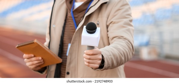 Male Reporter With Microphone At The Stadium, Closeup