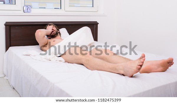 Male reproductive system. Why men get morning\
erections. Normal erections occur. Macho sexy guy torso relaxing\
lay bedroom. Morning wood formally known nocturnal penile\
tumescence common\
occurrence.