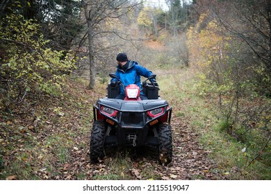 Male Rescuer In Protective Uniform On A Quad Bike Observe The Woods To Search And Save Missing Person