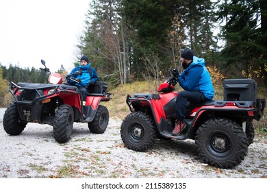 Male Rescuers With Amateur Radio In Protective Uniform On A Quad Bike Observe The Woods To Search And Save Missing Person