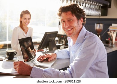 Male Restaurant Manager Working On Laptop