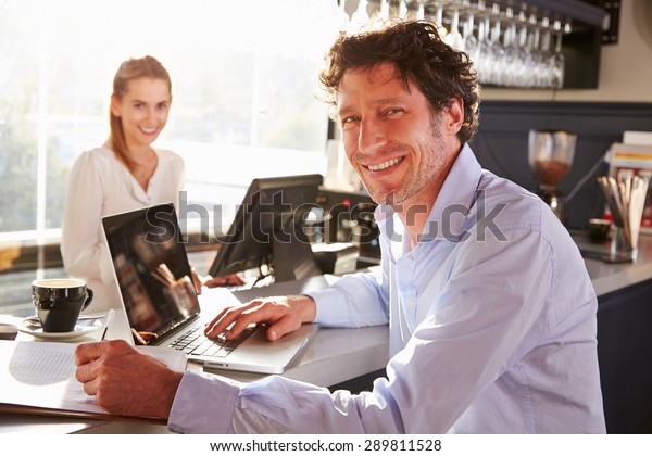 Male restaurant\
manager working on laptop
