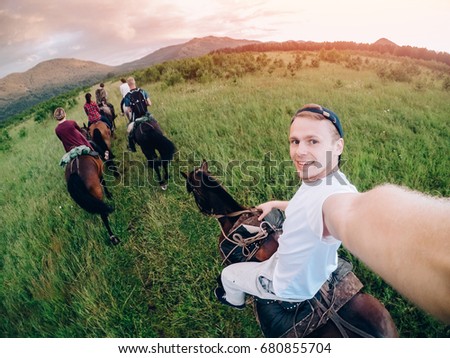 male rider on horseback holds a camera in his hand and takes a picture of Selfie.