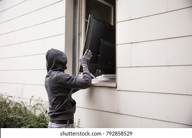 Male Robbers In Hoods Stealing Television Through House Window