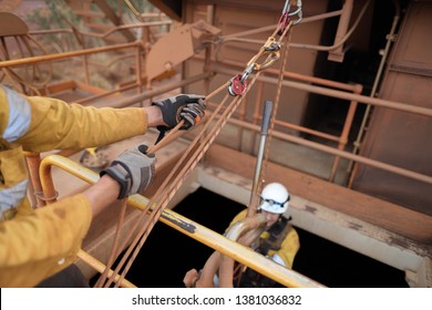 Male rope access industry worker hand wearing hand safety glove protection, while using mechanical advantage three two one pulley system lift the casualty up from confined space manhole construction - Powered by Shutterstock