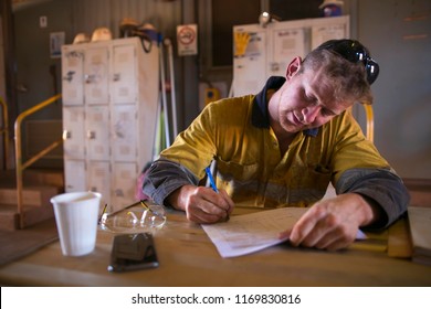 Male Rope Access Technician Miner Worker Setting On The Chair Table Writing Job Hazard Analysis Safety Preventing Assessment Control Prior Commencing Each Work At Construction Site Perth, Australia 
