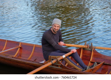 Male Rower On Thames Wearing Beanie Hat In A Skiff Boat