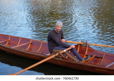 Male Rower On Thames Wearing Beanie Hat In A Skiff Boat