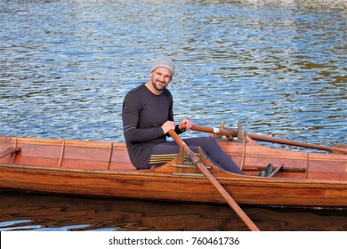 Male Rower On Thames Wearing Beanie Hat In A Skiff Boat