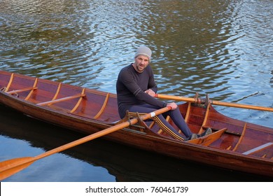 Male Rower On Thames Wearing Beanie Hat In A Skiff Boat