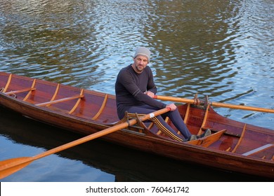 Male Rower On Thames Wearing Beanie Hat In A Skiff Boat