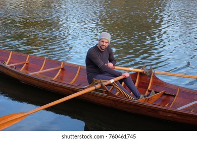 Male Rower On Thames Wearing Beanie Hat In A Skiff Boat