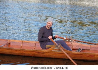 Male Rower On Thames Wearing Beanie Hat In A Skiff Boat