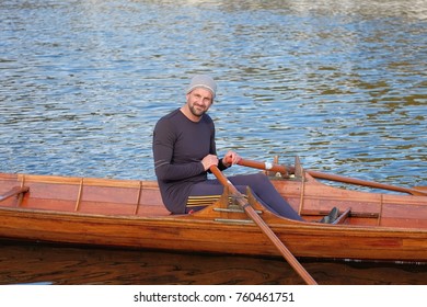 Male Rower On Thames Wearing Beanie Hat In A Skiff Boat