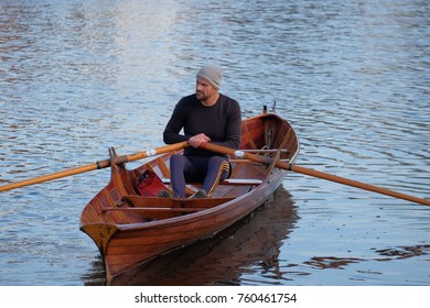 Male Rower On Thames Wearing Beanie Hat In A Skiff Boat