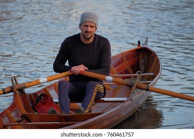 Male Rower On Thames Wearing Beanie Hat In A Skiff Boat