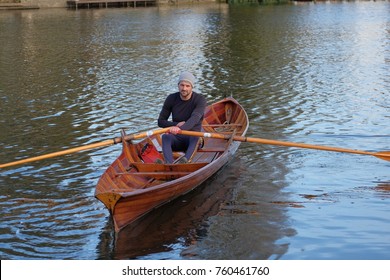 Male Rower On Thames Wearing Beanie Hat In A Skiff Boat