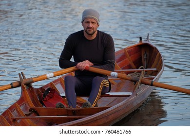 Male Rower On Thames Wearing Beanie Hat In A Skiff Boat