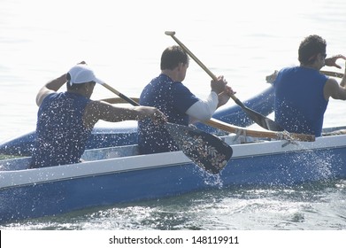 Male Rowers Paddling Outrigger Canoe In Race