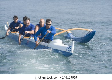 Male Rowers Paddling Outrigger Canoe In Race