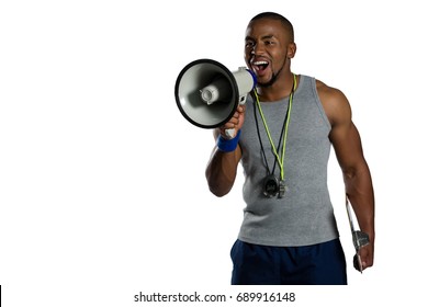 Male rugby instructor announcing on megaphone while standing against white background - Powered by Shutterstock