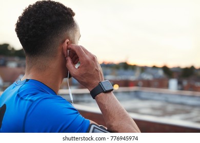 Male runner adjusting earphones in urban setting, close up - Powered by Shutterstock