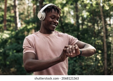 Male runner, American man checking fitness progress on his smartwatch, Black man using fitness app to track workout results while walking in the woods in nature - Powered by Shutterstock