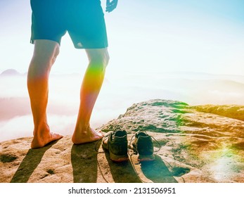 Male runner bare feet legs and sweaty running sneakres and rocky peak. Misty morning mountains.  Abstract lighting, colorful flare. - Powered by Shutterstock