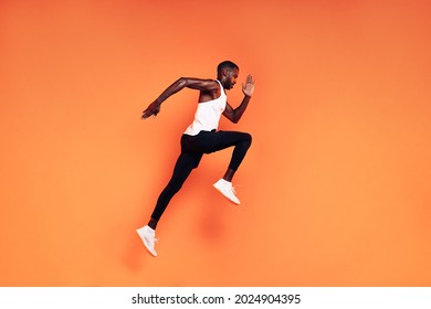 Male runner doing fitness workout. Athlete exercising over an orange background. - Powered by Shutterstock