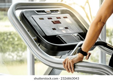 Male runner hands holding treadmill sidebar prepare for running in fitness gym. Indoor cardio workout machine