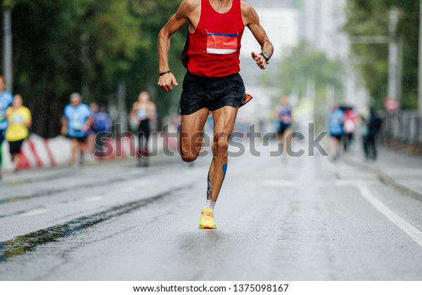 male\
runner leader of city marathon race run in\
rain