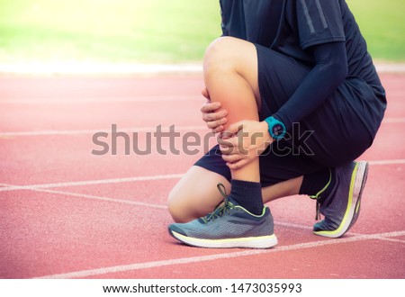 Male runner shin bone injury and pain on running track,Injury from workout concept 