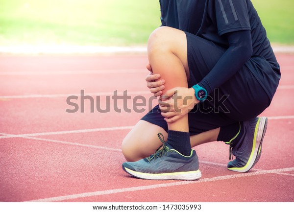 Male runner shin bone injury and pain on\
running track,Injury from workout concept\
