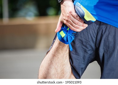 Male Runner Stretching Before Workout.