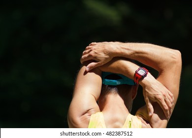 Male Runner Stretching Outdoors. Triceps Stretch.