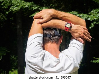 Male Runner Stretching Outdoors. Triceps Stretch.