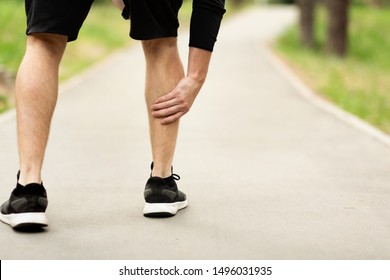 Male Runner Is Suffering From Calf Leg Pain Or Sprain On Jogging, Holding Sore And Painful Muscle, Free Space